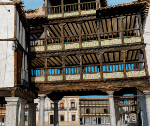 Pintura realista del arco principal de la plaza mayor de Tembleque que consta de tres pisos, el tercero de menores dimensiones y cubierto con un tejado a cuatro aguas